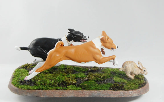 Basenjis chasing a rabbit