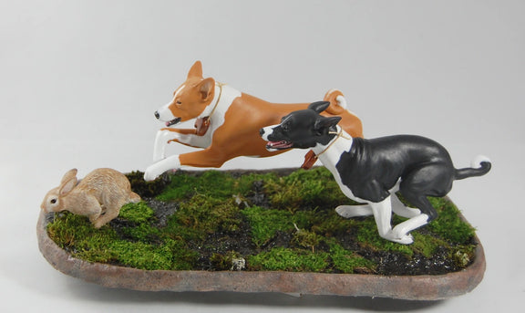 Basenjis chasing a rabbit