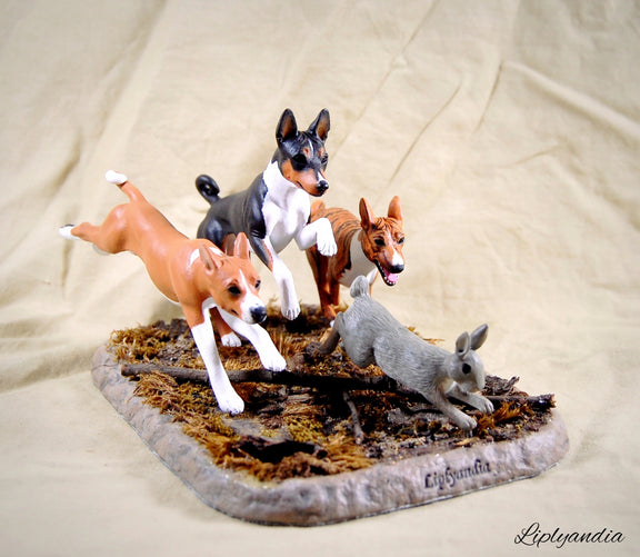 Basenjis chasing a rabbit